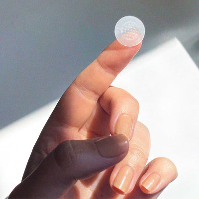 Pimple patch perched on finger