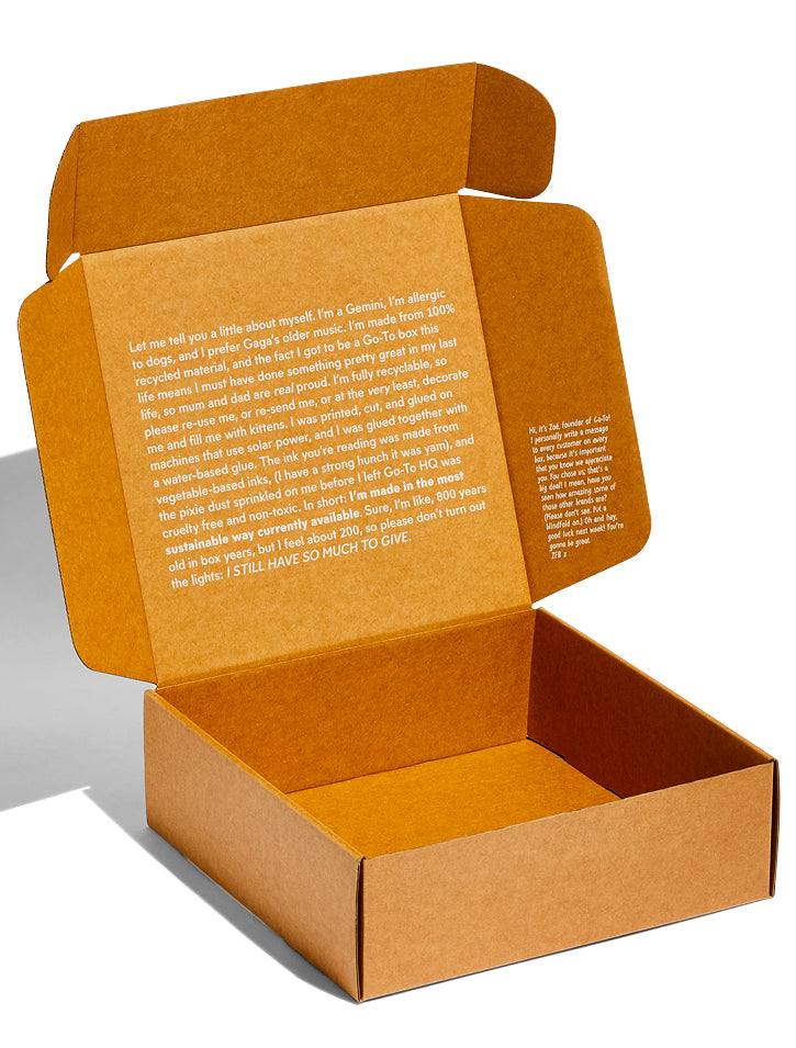 An open brown cardboard box with white printed text on the inner lid describing the box’s eco-friendly qualities, recycled materials, and encouraging reuse. The box is empty and positioned on a white background.