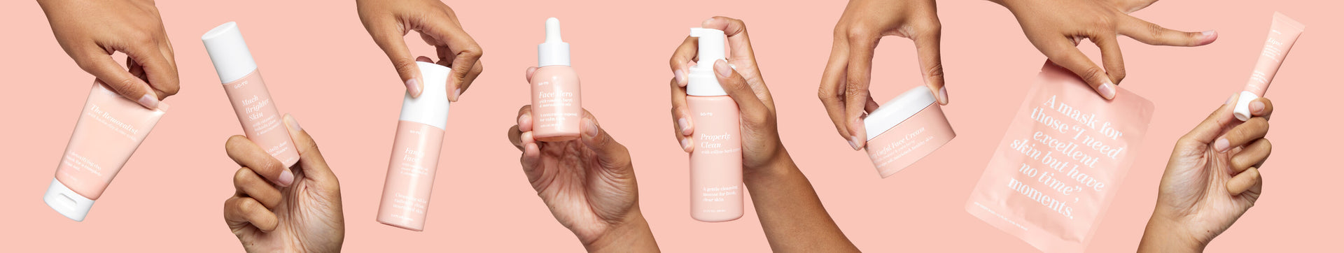 Multiple hands holding various pink skincare products, including bottles, tubes, a jar, a dropper, and a sheet mask, all against a light pink background.