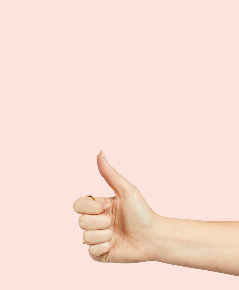 A hand giving a thumbs-up gesture against a plain light pink background.