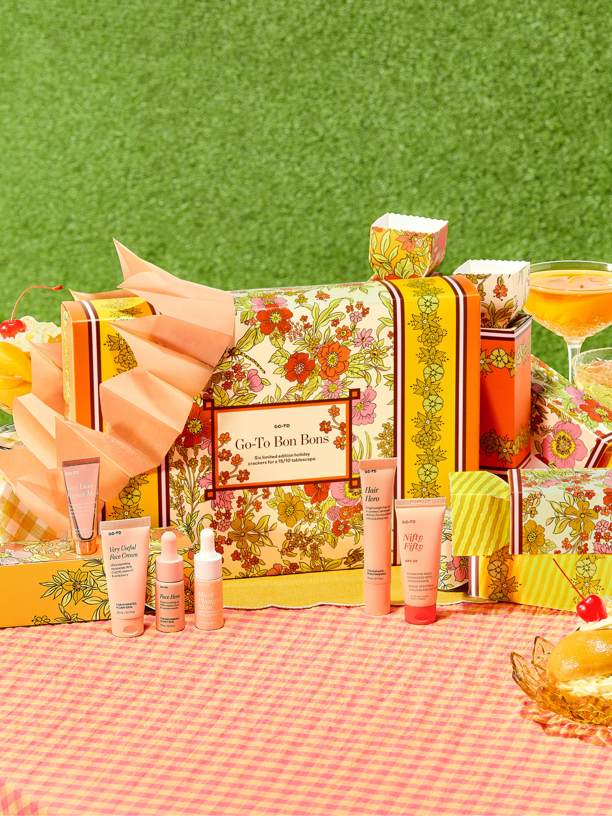 Go-To Skincare Bon Bons shown as a festive floral gift box with skincare minis on a bright picnic table beside party treats and drinks